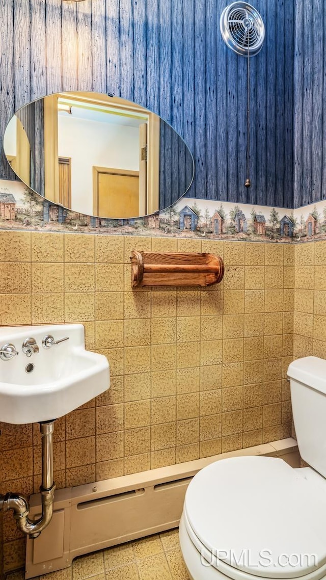 bathroom featuring tile walls and toilet