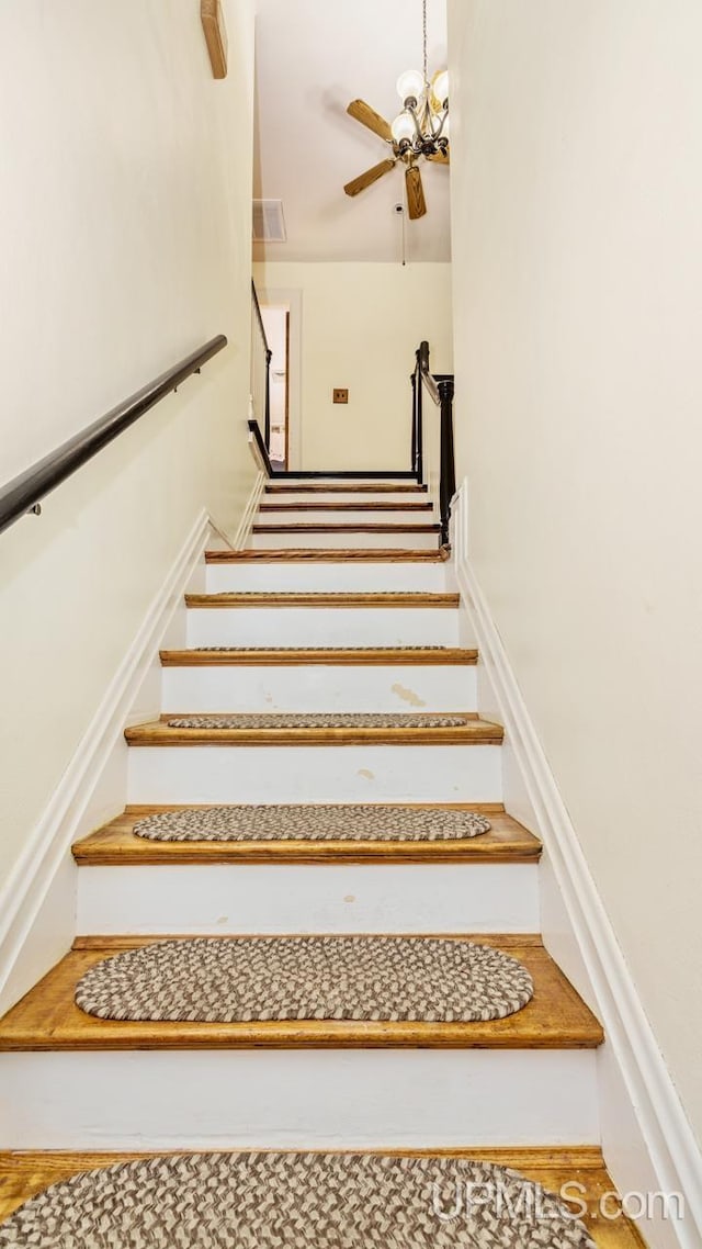 stairs featuring ceiling fan