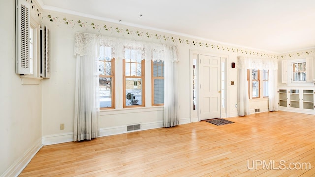 entryway with hardwood / wood-style flooring and ornamental molding