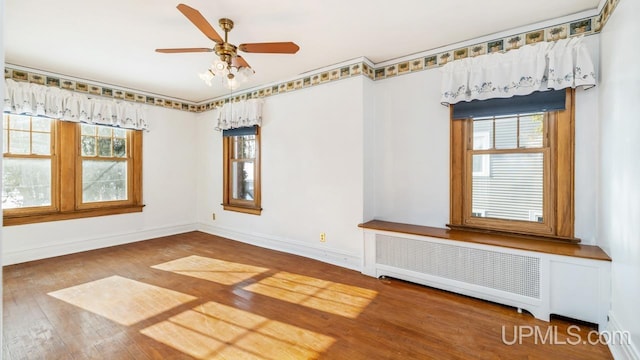 spare room with ceiling fan, radiator, and hardwood / wood-style floors