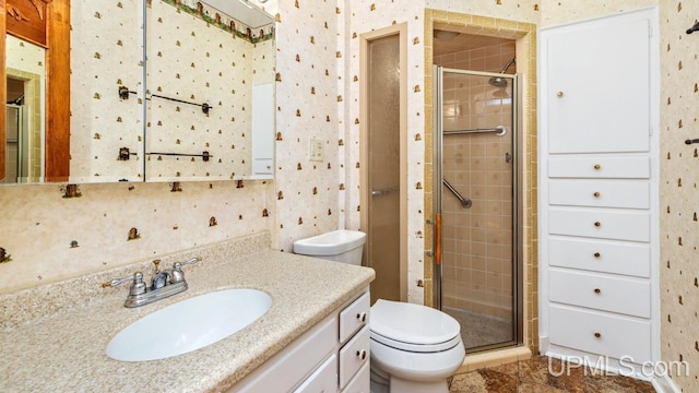 bathroom featuring toilet, vanity, and walk in shower