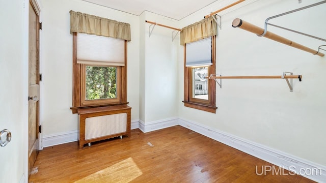 unfurnished room with hardwood / wood-style flooring and radiator