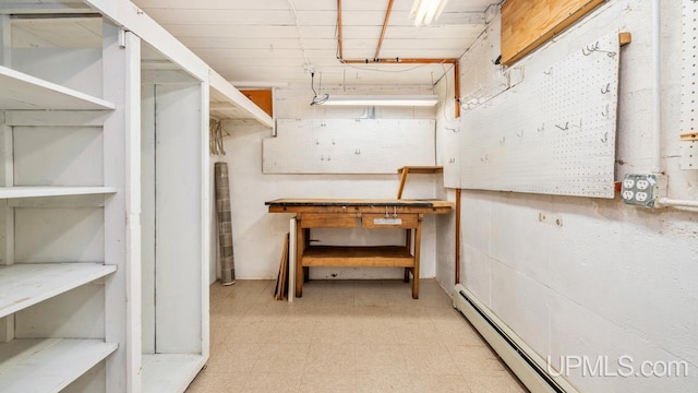 basement featuring a baseboard radiator and a workshop area