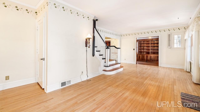 workout room featuring ornamental molding and hardwood / wood-style floors