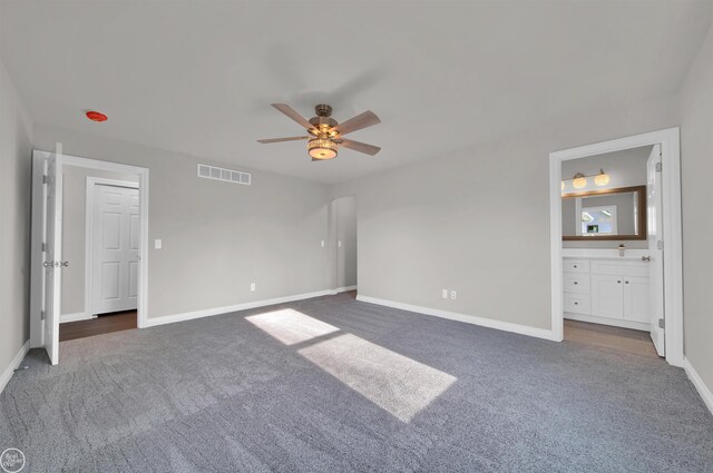 1834 Riley Rd, Saint Clair, MI 48079 - unfurnished bedroom with connected bathroom, ceiling fan, and dark colored carpet