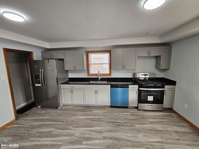 kitchen with light hardwood / wood-style flooring, sink, gray cabinets, and appliances with stainless steel finishes