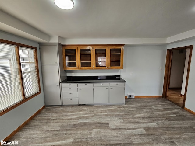 kitchen with light hardwood / wood-style floors and white cabinets