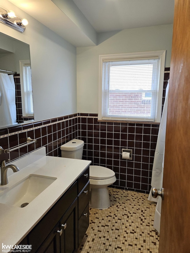 bathroom featuring vanity, tile patterned flooring, toilet, and tile walls