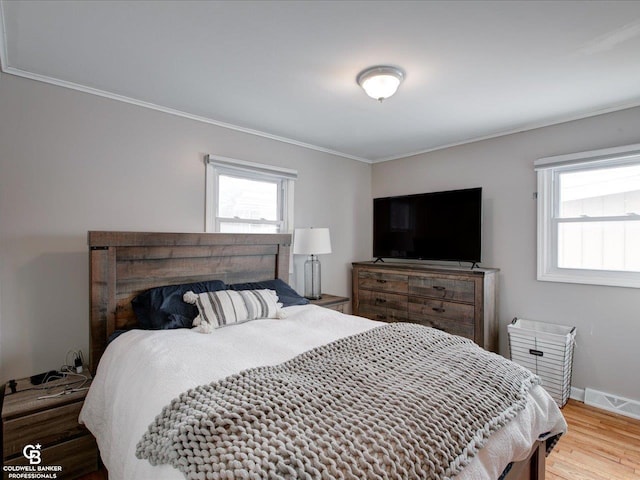 bedroom with wood-type flooring and ornamental molding