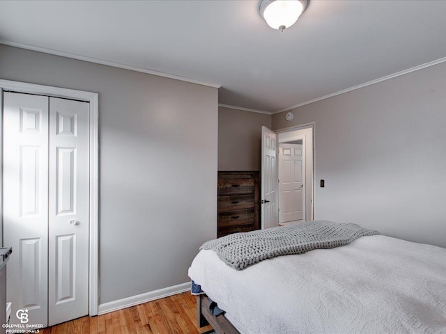 bedroom featuring ornamental molding, a closet, and light wood-type flooring