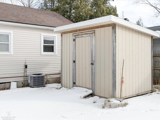 snow covered structure featuring central AC unit