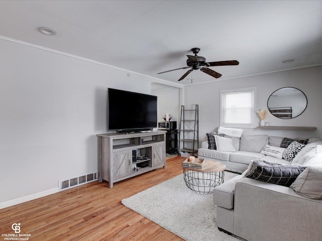 living room featuring crown molding, ceiling fan, and light wood-type flooring