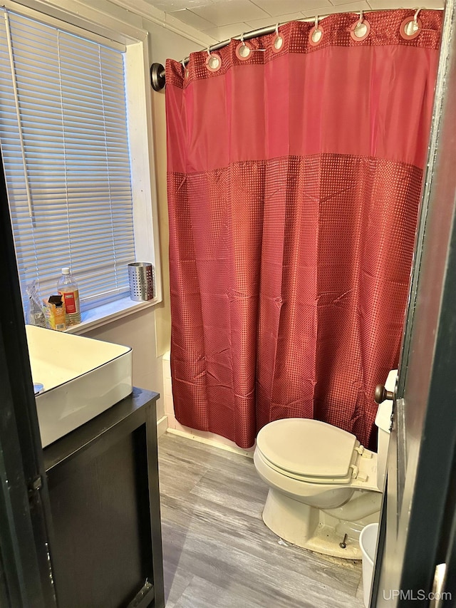 full bathroom with shower / bathtub combination with curtain, vanity, toilet, and hardwood / wood-style floors