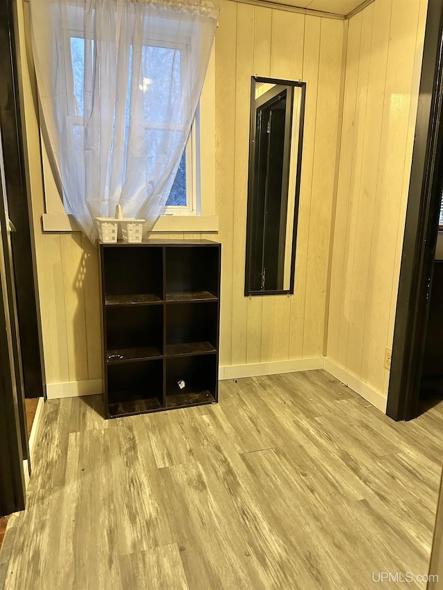 interior space featuring light hardwood / wood-style floors and wood walls