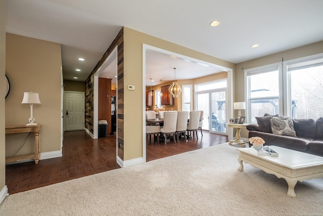 carpeted living room featuring an inviting chandelier