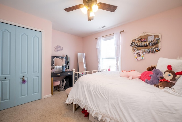 carpeted bedroom featuring ceiling fan and a closet