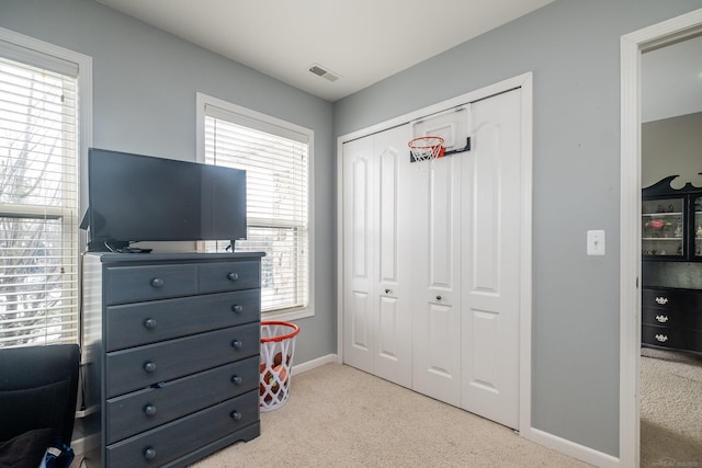 interior space featuring light carpet and a closet