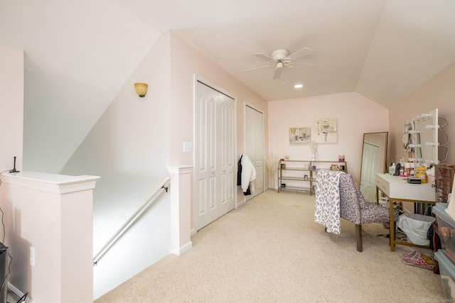 interior space featuring ceiling fan, light colored carpet, and lofted ceiling