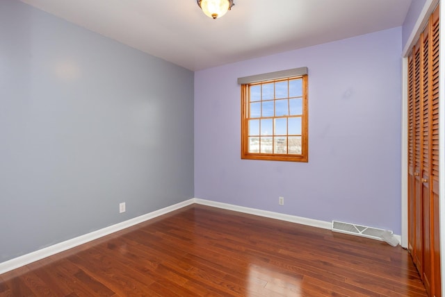 unfurnished bedroom featuring dark hardwood / wood-style flooring and a closet