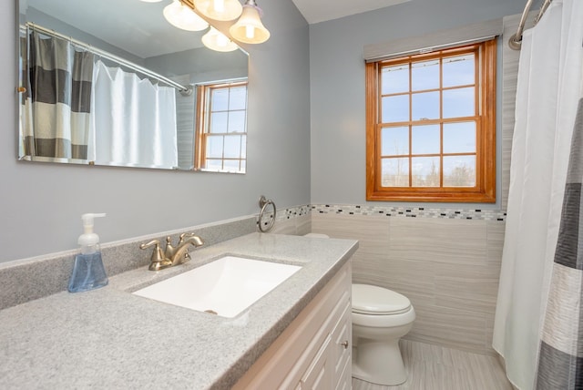 bathroom featuring vanity, tile walls, walk in shower, and toilet