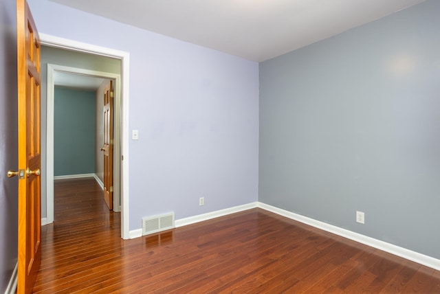 unfurnished room with dark wood-type flooring