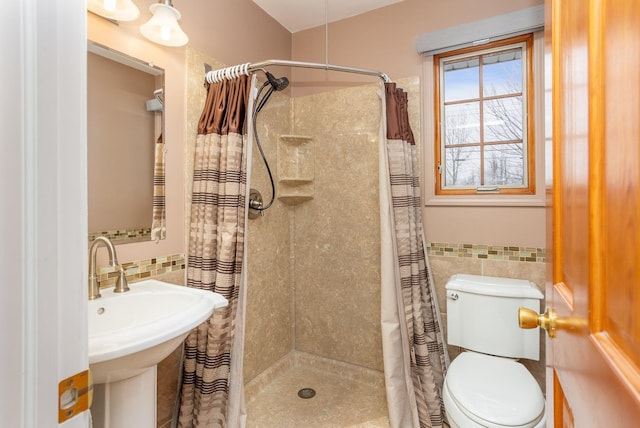 bathroom with sink, tile walls, curtained shower, and toilet