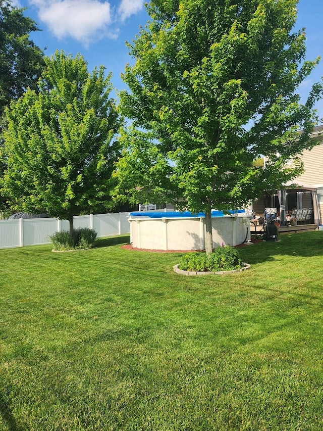 view of yard with a fenced in pool