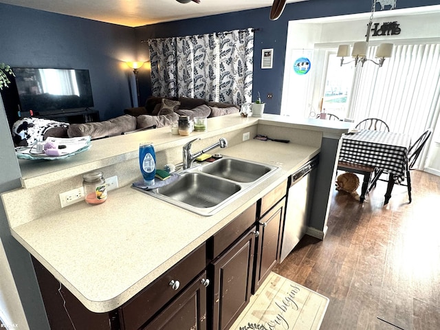 kitchen with sink, dark hardwood / wood-style flooring, stainless steel dishwasher, a notable chandelier, and dark brown cabinetry