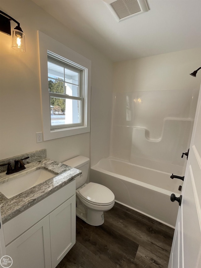 full bathroom featuring wood-type flooring, toilet, tub / shower combination, and vanity