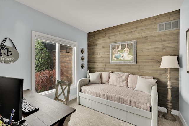 carpeted living room with wood walls