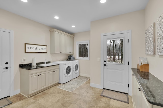 clothes washing area with cabinets, sink, and washer and clothes dryer