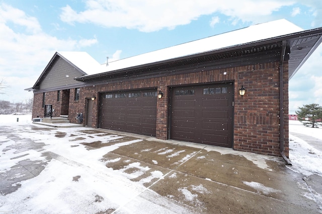 snow covered property featuring a garage