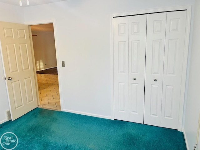 unfurnished bedroom featuring dark carpet and a closet