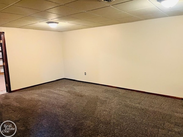 spare room featuring carpet and a paneled ceiling