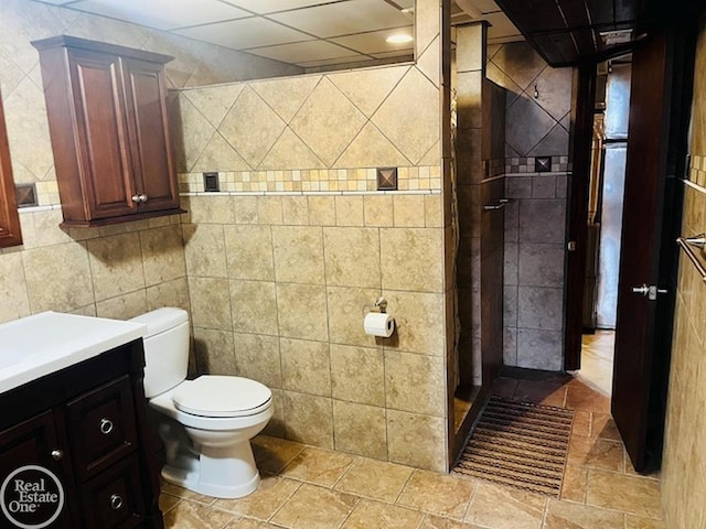 bathroom with vanity, tile walls, and toilet