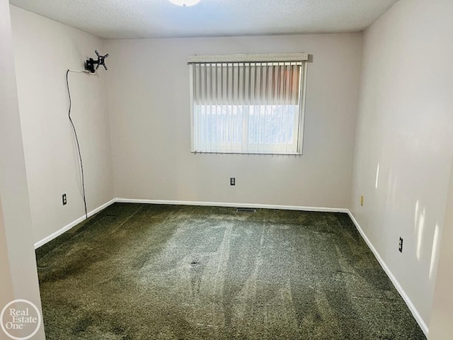 carpeted spare room with a textured ceiling