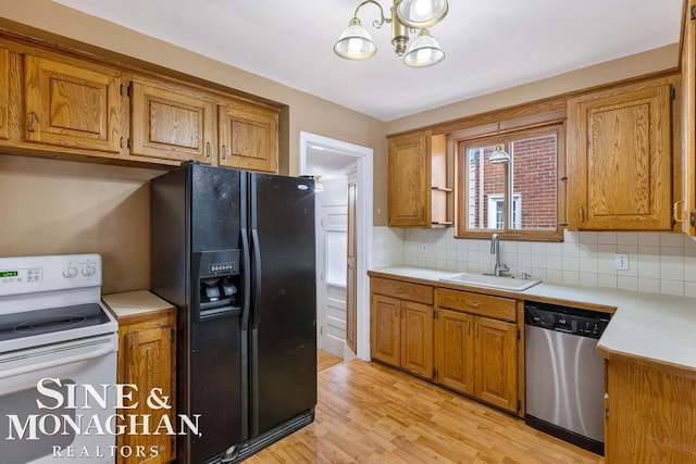 kitchen featuring sink, white range with electric stovetop, decorative backsplash, black fridge with ice dispenser, and stainless steel dishwasher