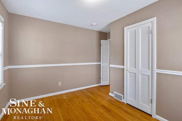 unfurnished bedroom featuring light hardwood / wood-style floors and a closet