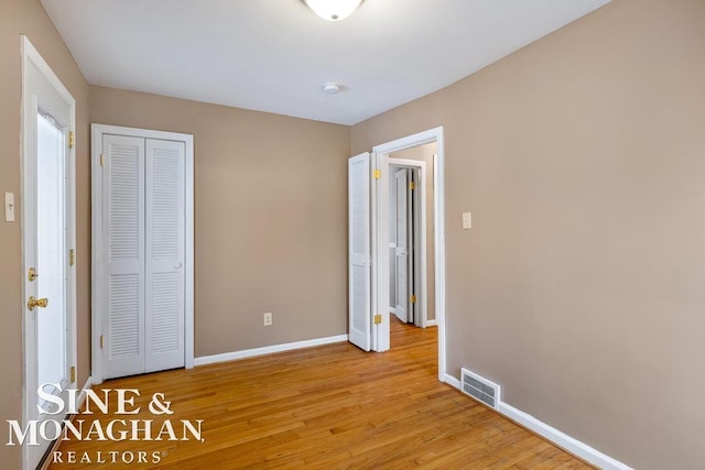 unfurnished bedroom featuring light hardwood / wood-style floors and a closet