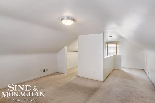 bonus room featuring lofted ceiling and light carpet