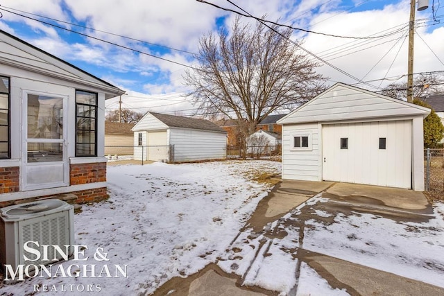 yard layered in snow with a storage unit and central AC unit