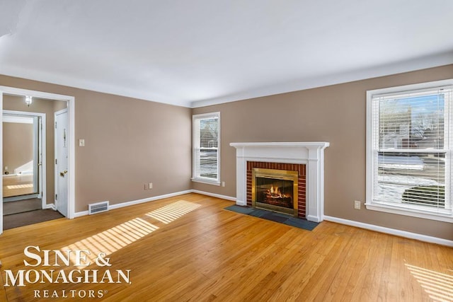 unfurnished living room with a fireplace and light wood-type flooring