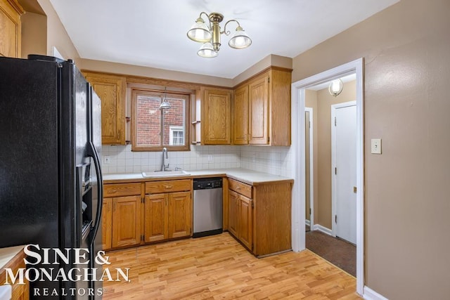 kitchen with black fridge with ice dispenser, sink, light hardwood / wood-style flooring, stainless steel dishwasher, and backsplash