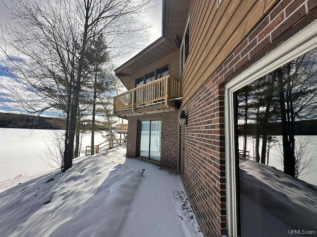 snow covered property featuring a balcony