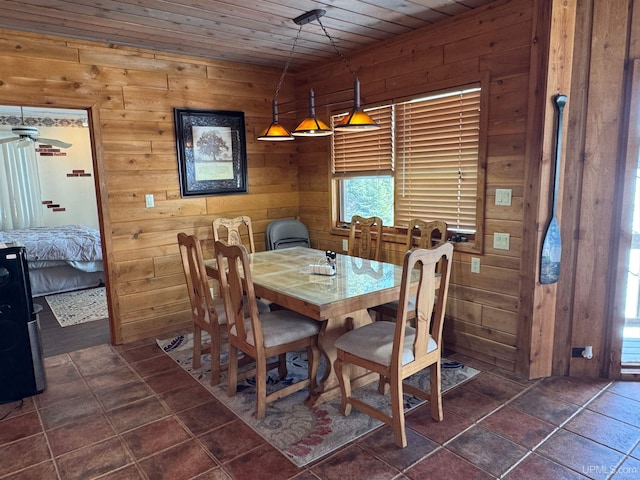 dining room with wooden ceiling and wooden walls