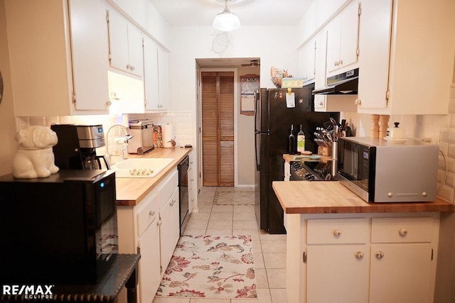 kitchen with butcher block countertops, sink, black dishwasher, tasteful backsplash, and white cabinets