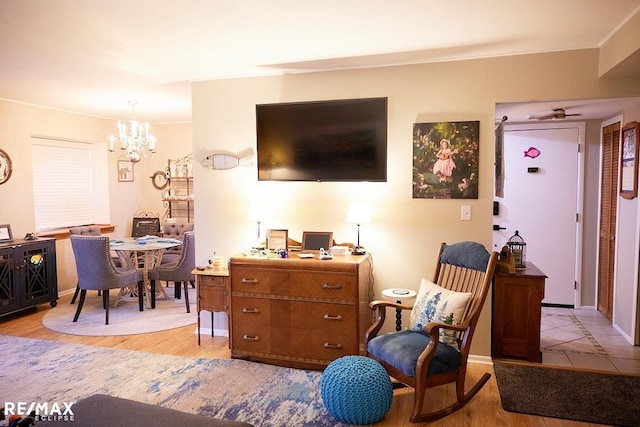 living room with crown molding, a chandelier, and light hardwood / wood-style floors