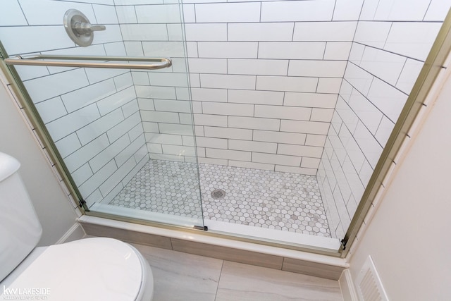 bathroom featuring an enclosed shower and toilet