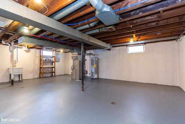 basement featuring heating unit, electric panel, and water heater