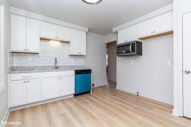 kitchen with sink, light stone counters, white cabinets, stainless steel appliances, and backsplash